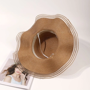 Detail of caramel straw sun hat with wavy brim, inner sweatband and elastic chin strap