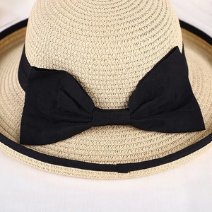 Close-up of fine straw weave texture with black grosgrain bow and edge binding