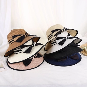 Dettaglio di cappelli di paglia intrecciati in vari colori con eleganti fiocchi neri M