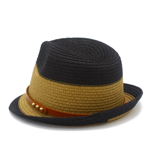 Detail of two-tone straw fedora showing brown leather band and gold metal studs