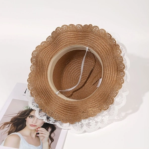 Close-up of straw sun hat featuring white lace trim, inner sweatband and windproof cord
