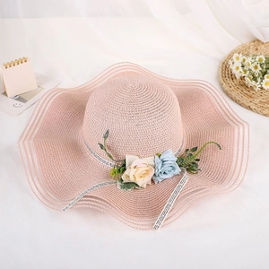 Summer wide brim straw hat with floral ribbon and wavy edge decoration in lotus pink