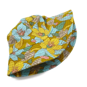Dettaglio cappello a secchiello floreale in tessuto giallo con fiori blu e tesa cucita