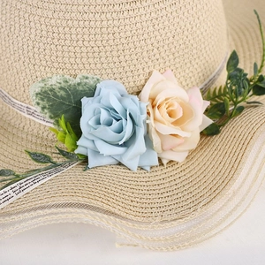 Women's wide brim straw sun hat with decorative floral roses and printed ribbon detail