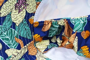 Dettaglio del cappello da sole con stampa tropicale, bordo elastico e fodera a rete