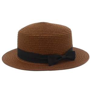 Dettaglio della trama di paglia marrone scuro del cappello con nastro in gros-grain nero