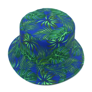 Top view of reversible bucket hat featuring vibrant green tropical leaf print on navy blue fabric