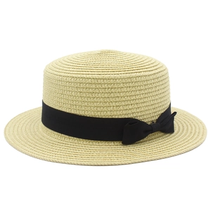 Dettaglio del cappello di paglia a testa piatta con nastro in canneté nero e fiocco