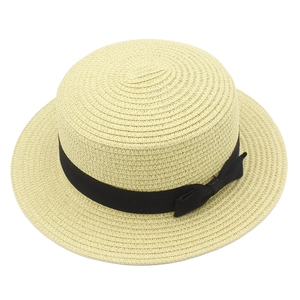 Dettaglio di cappello di paglia a testa piatta con trama intrecciata e fiocco nero