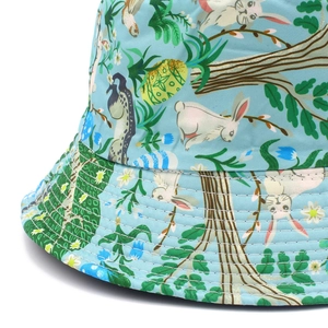 Dettaglio cappello da sole azzurro con stampa coniglio e impunture sulla tesa larga