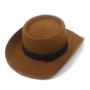 Close-up of deep brown straw cowboy hat featuring fine spiral weave and black ribbon band