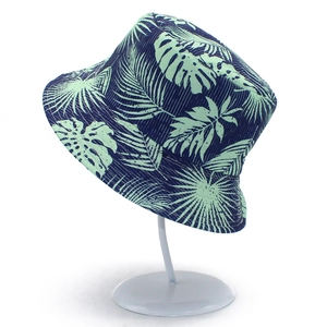 Reversible tropical print bucket hat with navy and mint green palm leaves for sun protection