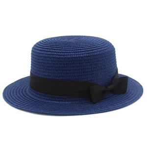 Dettaglio di un cappello di paglia blu navy con trama fine e fiocco in gros-grain nero