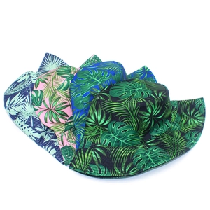 Detailed view of four colorful tropical plant print bucket hats on a white background