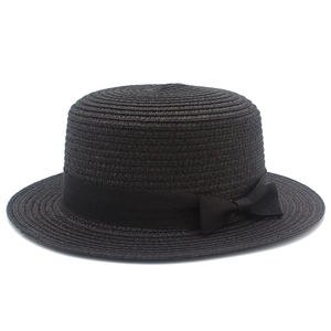 Dettaglio del cappello di paglia boater nero con trama a spirale e nastro di raso