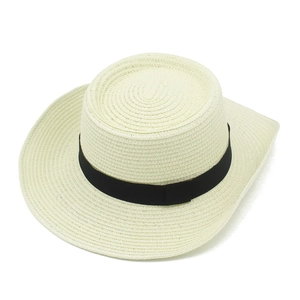 Detail of cream woven straw hat texture with decorative wide black ribbon band