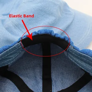 Detail view of the black elastic band inside a light blue denim baker boy cap