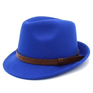 Detail of royal blue fedora hat featuring a vintage brown patterned belt on white background