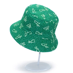 Detailed view of green bucket hat with white cartoon bunny print and neat stitching