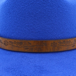 Detailed close-up of the royal blue wool felt fedora featuring a floral embossed brown band