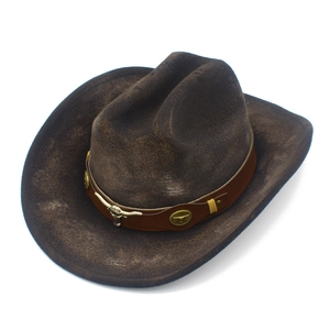 Detalle de sombrero vaquero marrón con emblema de cabeza de toro en bronce y banda de cuero