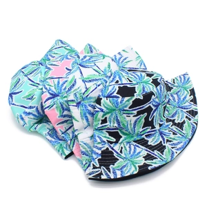 Detail of colorful bucket hats featuring tropical palm tree leaf patterns in four colors