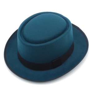 Détail d'un chapeau en feutre bleu sarcelle avec ruban noir et texture de surface fine