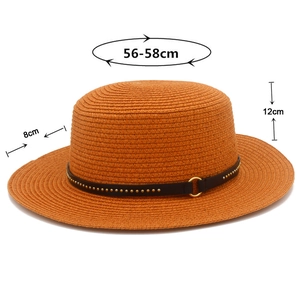 Detail view of woven straw boater hat with faux leather belt and gold metallic studs