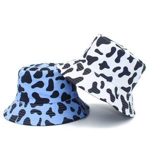 Detail view of cotton bucket hats featuring stylish black-white and blue-white cow prints