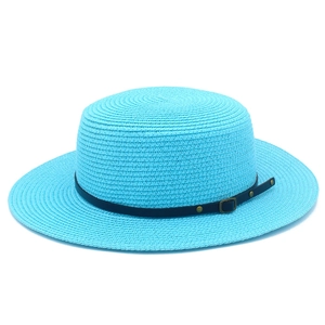 Detail of blue straw sun hat with black leather band and golden metal buckle decoration