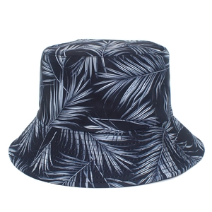 Detailed view of black bucket hat with white tropical palm leaf patterns and sturdy brim