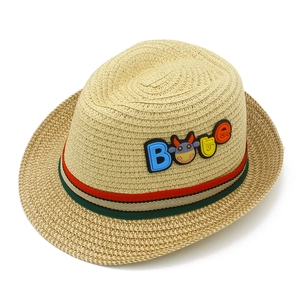 Dettaglio cappello di paglia per bambini con nastro a righe e patch mucca cartoon
