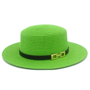 Dettaglio della trama del cappello di paglia verde lime con nastro nero e fibbia oro
