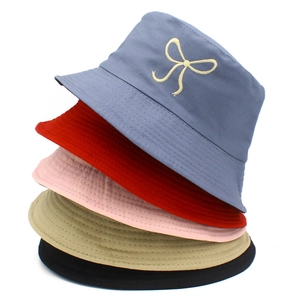 Close-up of embroidered bow detail on cotton bucket hats in five assorted colors