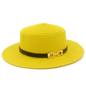 Dettaglio di cappello di paglia giallo a cima piatta con fascia nera e fibbia d'oro