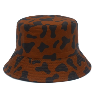 Detail showing the brown cow print bucket hat with reinforced parallel brim stitching