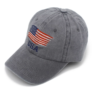 Detailed close-up of embroidered USA flag and text on grey washed denim baseball cap