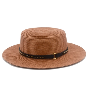 Close-up of woven straw hat featuring a brown leather band with golden metal rivets