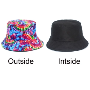 Detailed view of the reversible bucket hat showing rainbow tie-dye and solid black sides