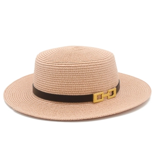 Dettaglio del cappello paglia beige con fascia in pelle nera e fibbia in metallo dorato