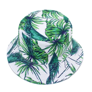 Close-up of tropical green palm leaf print on white cotton foldable bucket sun hat