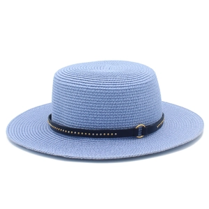 Detail of light blue straw boater hat featuring a black leather band with metallic studs