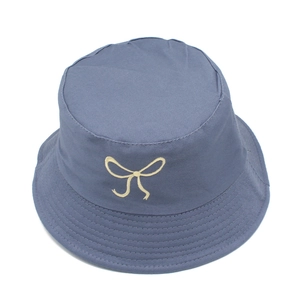 Detail showing high-quality embroidery of a yellow bow on this grey-blue cotton bucket hat