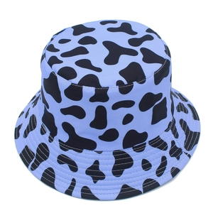 Detail view of purple bucket hat with black cow print and stitched brim for sun protection