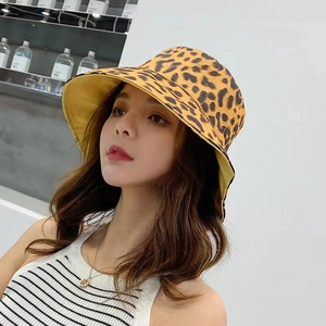 Detail of a reversible leopard print bucket hat with a wide brim on a female model