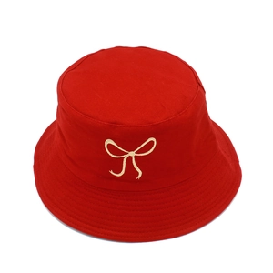 Detail of red cotton bucket hat featuring delicate white bow embroidery and stitching