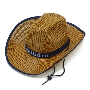 Détail d'un chapeau de cowboy en paille avec bande décorative bleue et mentonnière