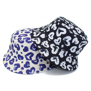 Detail view of two cotton bucket hats with blue and white heart graffiti patterns