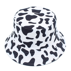 Detail of cow print bucket hat featuring black and white spots with reinforced stitching
