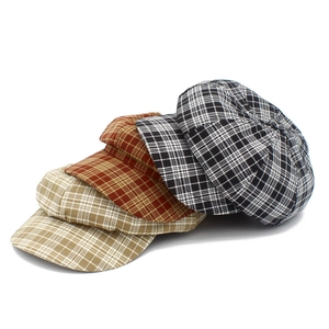 Gros plan de casquettes gavroche vintage à carreaux en kaki et marron avec texture de tissu